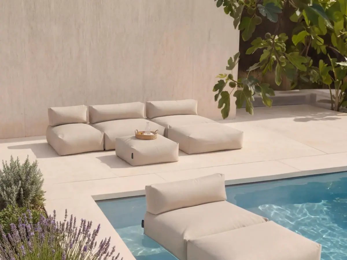 Pool mit weißen Kissen und einem Tisch.
