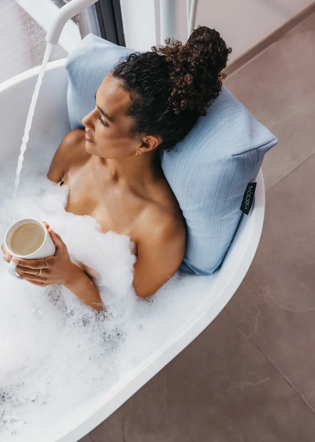 Eine Frau in einer Badewanne mit Schaum.