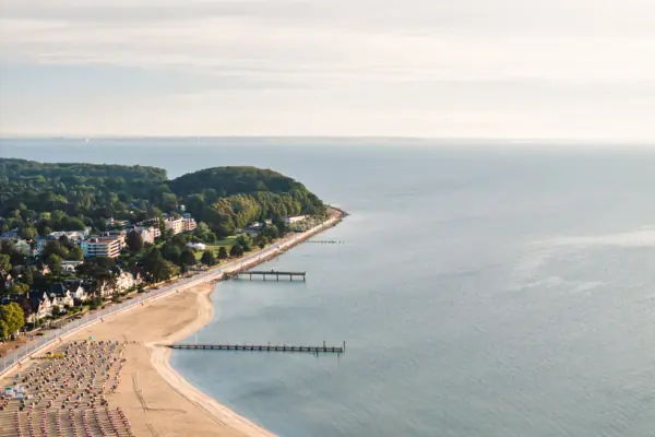 Die Küste von Travemünde mit einem langen Strand mit vielen Strandkörben und der Ostsee.
