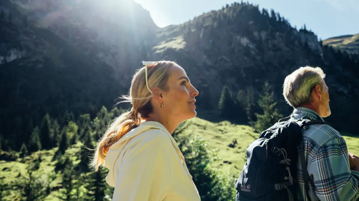 Eine Frau und ein Mann wandern in den Bergen.