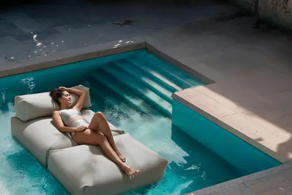 Eine Frau liegt auf einer Matratze in einem Pool.