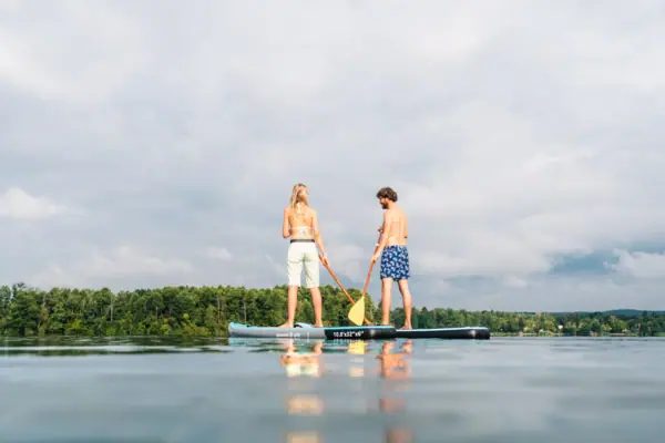 Ein Mann und eine Frau auf einem Paddleboard auf dem Wasser.