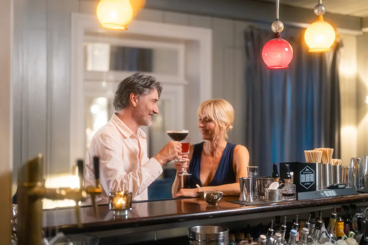 Ein Mann und eine Frau trinken Cocktails an der Bar im Louis C. Jacob Hotel Hamburg.