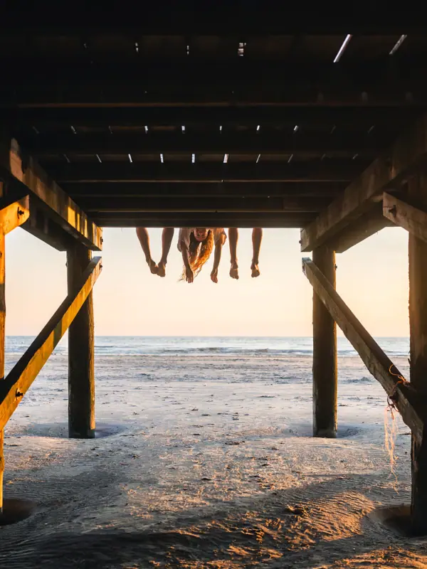 Eine Gruppe von Menschen auf einem hölzernen Bauwerk am Strand von St. Peter-Ording.