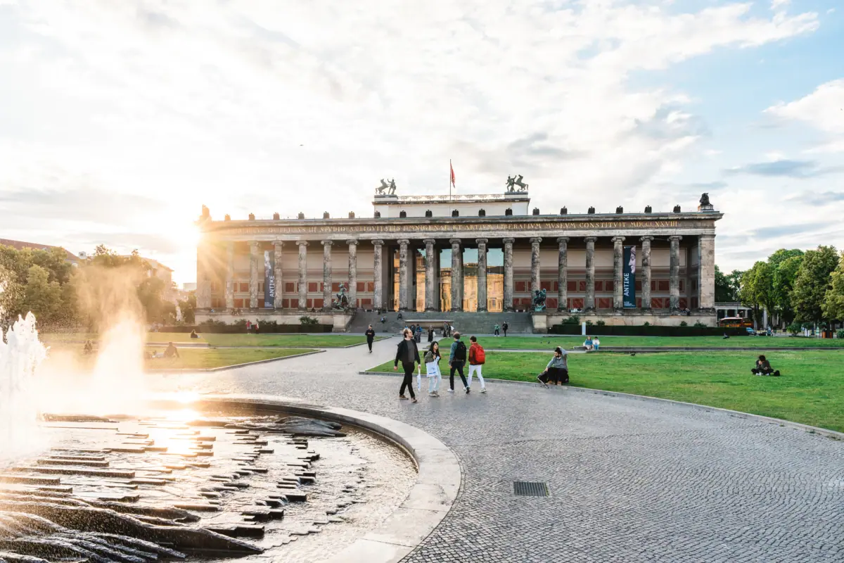 Ein Brunnen im Vordergrund mit einem Gebäude im Hintergrund.