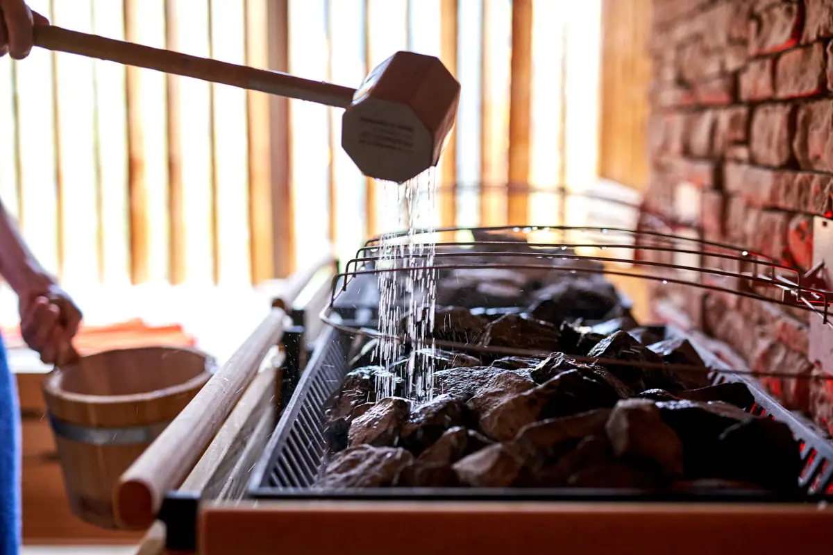 Ein Holzhammer gießt Wasser auf einen Grill.