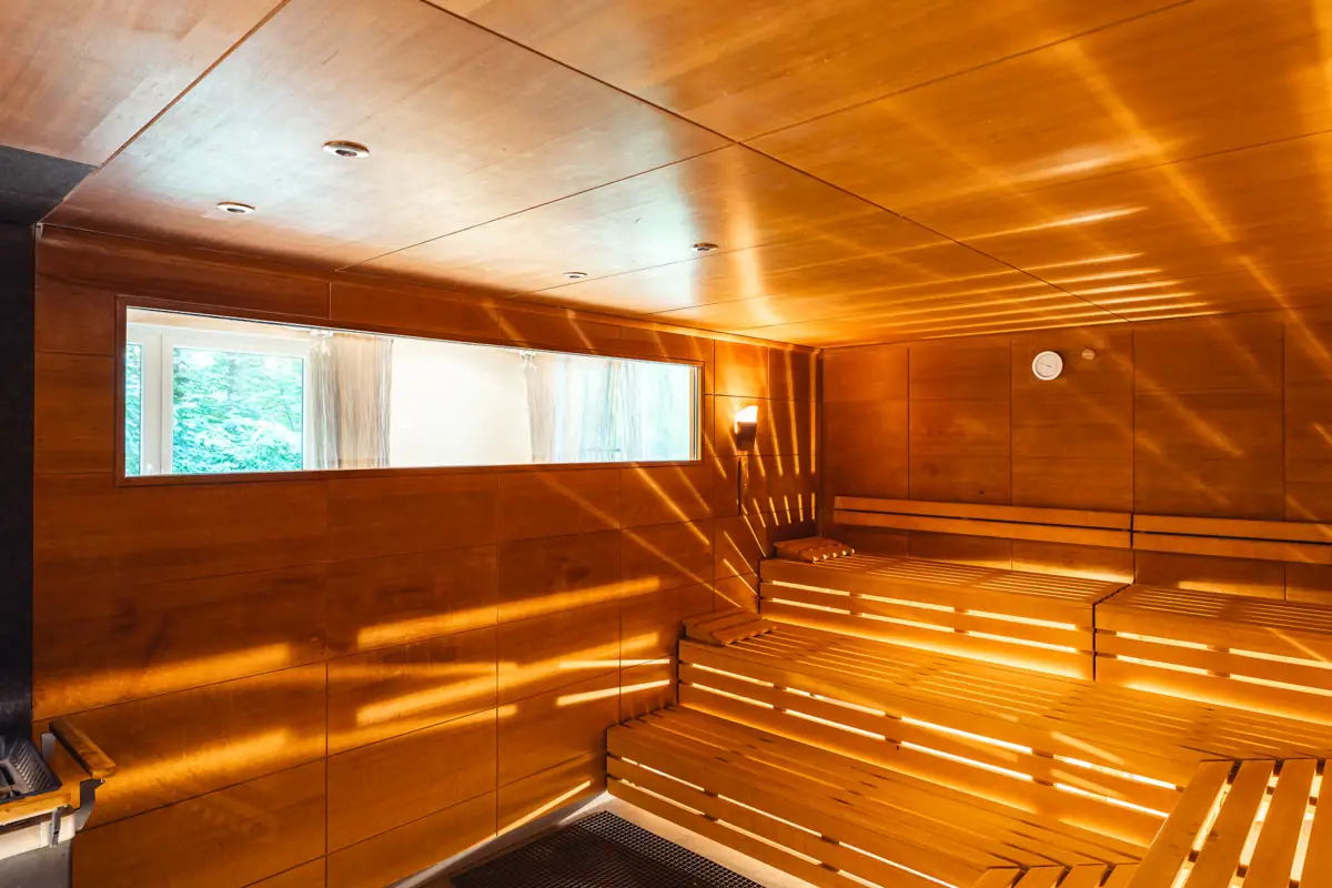 Holzsauna mit Sonnenstrahlen, die durch die Wände scheinen