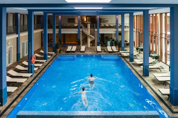 Zwei Personen schwimmen in einem Swimmingpool.