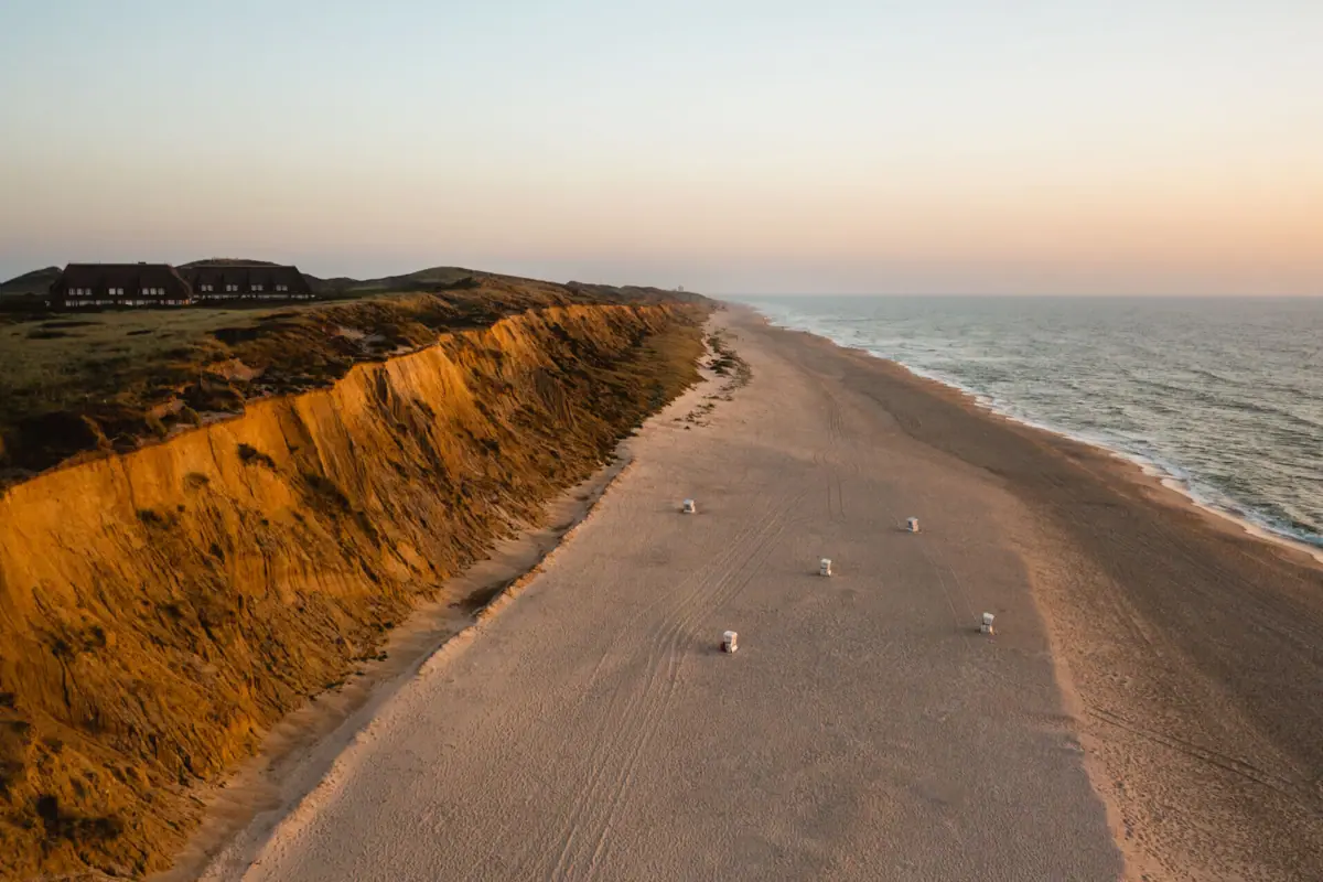 Das Rote Kliff auf Sylt bei Sonnenuntergang mit dem Strand und der Nordsee.
