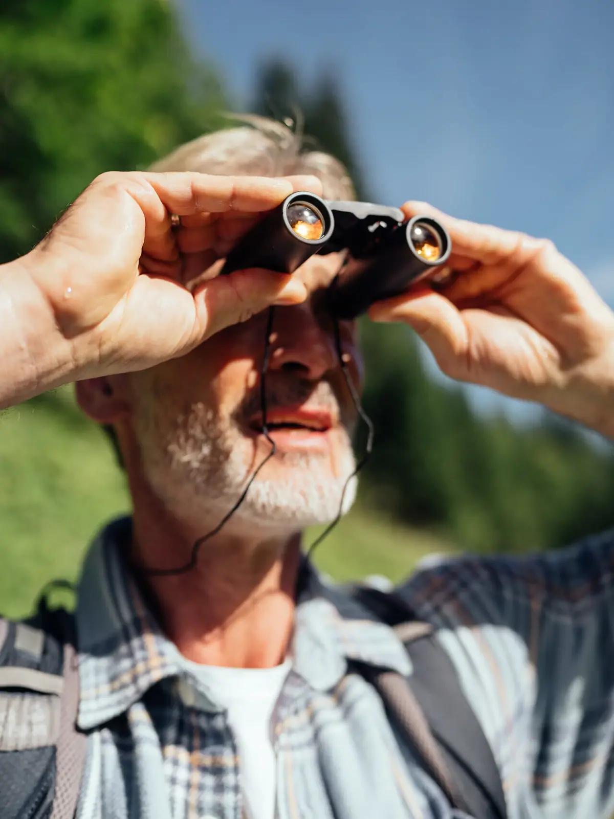 Ein Mann schaut durch ein Fernglas im Bärgunttal.