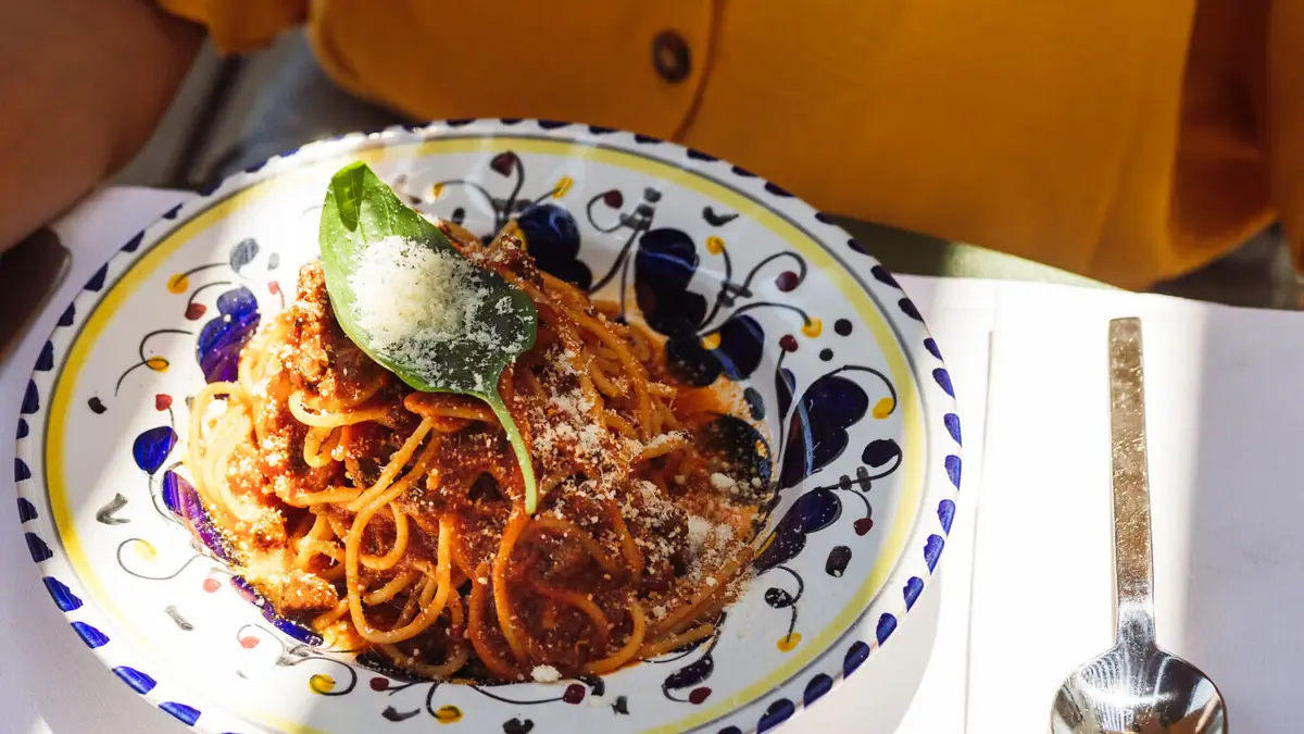 Ein Teller mit Pasta, einer Gabel und einem Löffel.
