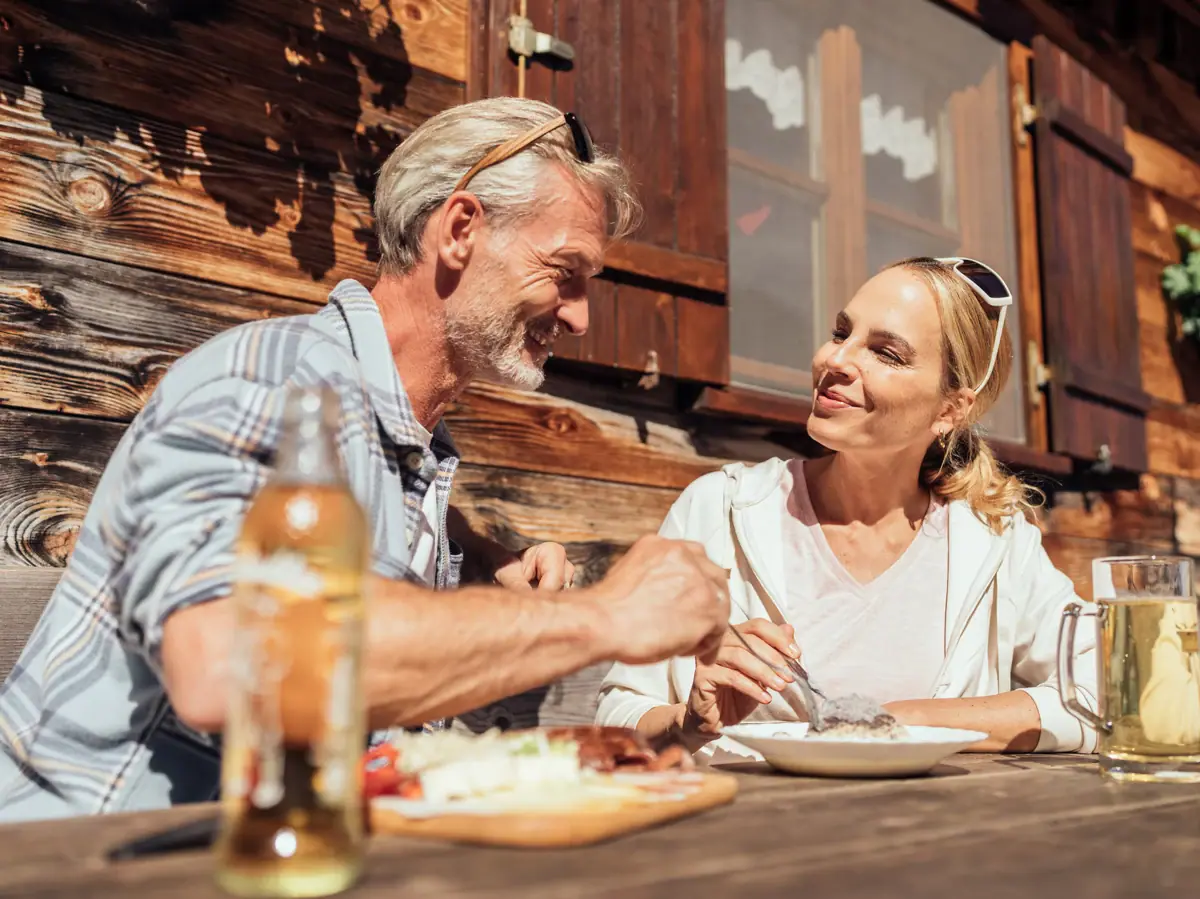Ein Mann und eine Frau essen an einem Tisch in der Bärgunthütte.