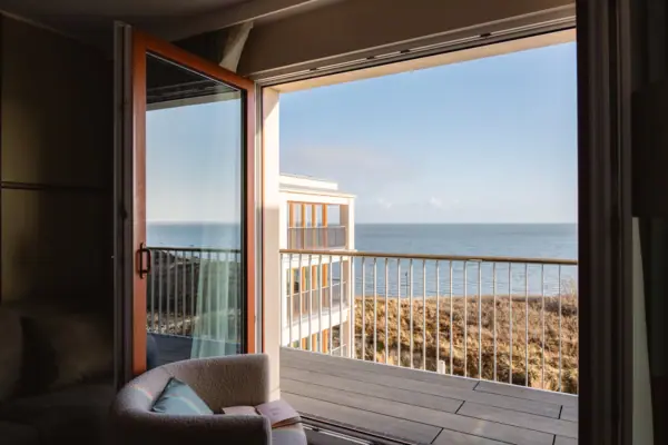 Urlaub am Wattenmeer mit Blick aus einem Hotelzimmer vom A-ROSA Sylt mit Dünen und der Nordsee.