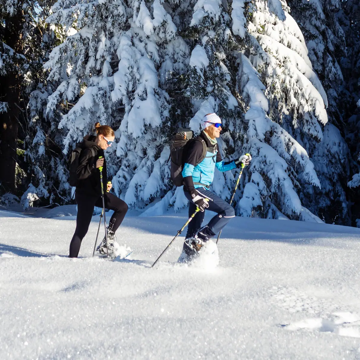 Zwei Perosnen wandern durch dichten Schnee