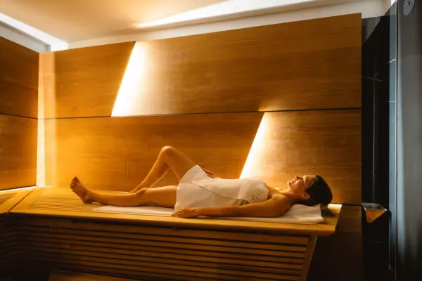 Eine Frau liegt auf einer Bank in einer Sauna.