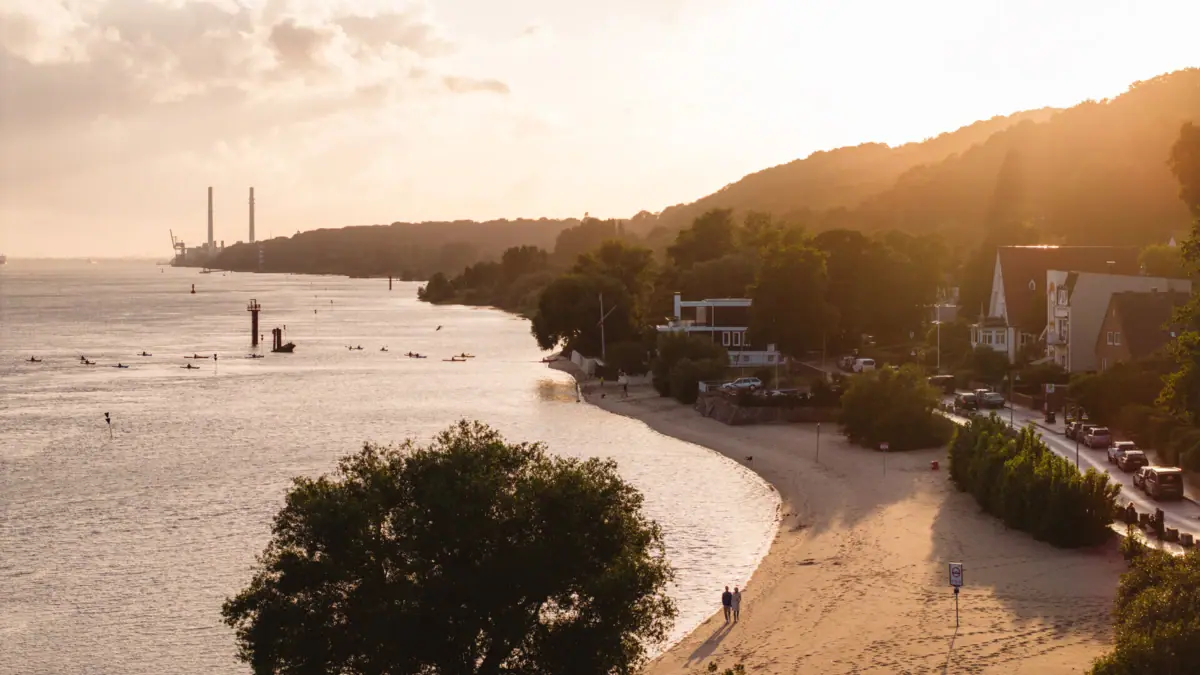 Strand mit Bäumen und Gebäuden an der Seite