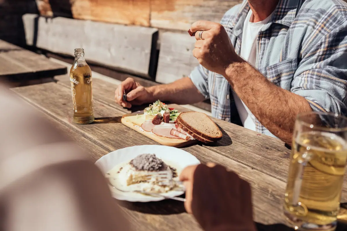 Ein Mann isst Essen an einem Tisch in der Bärgunthütte.