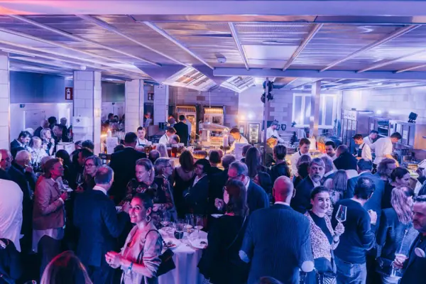 Eine Küchenparty im Louis C. Jacob Hotel in Hamburg mit vielen Menschen und stimmungsvollem Licht in der großen Hotelküche.