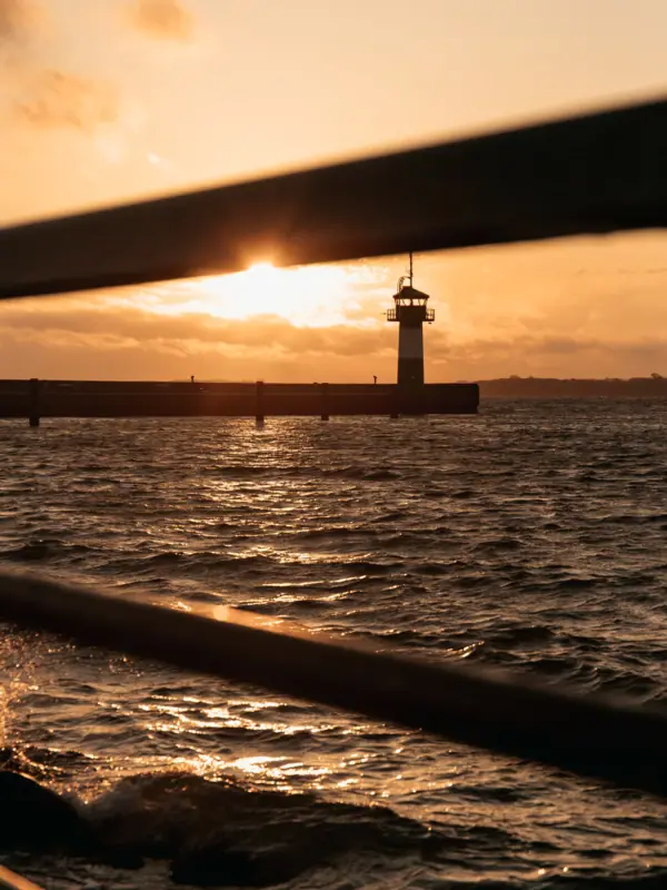 Das Molefeuer in Travemünde bei Sonnenaufgang mit der Ostsee.