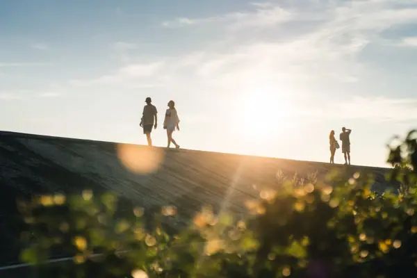 Eine Gruppe von Menschen wandert auf dem Deich von St. Peter-Ording.