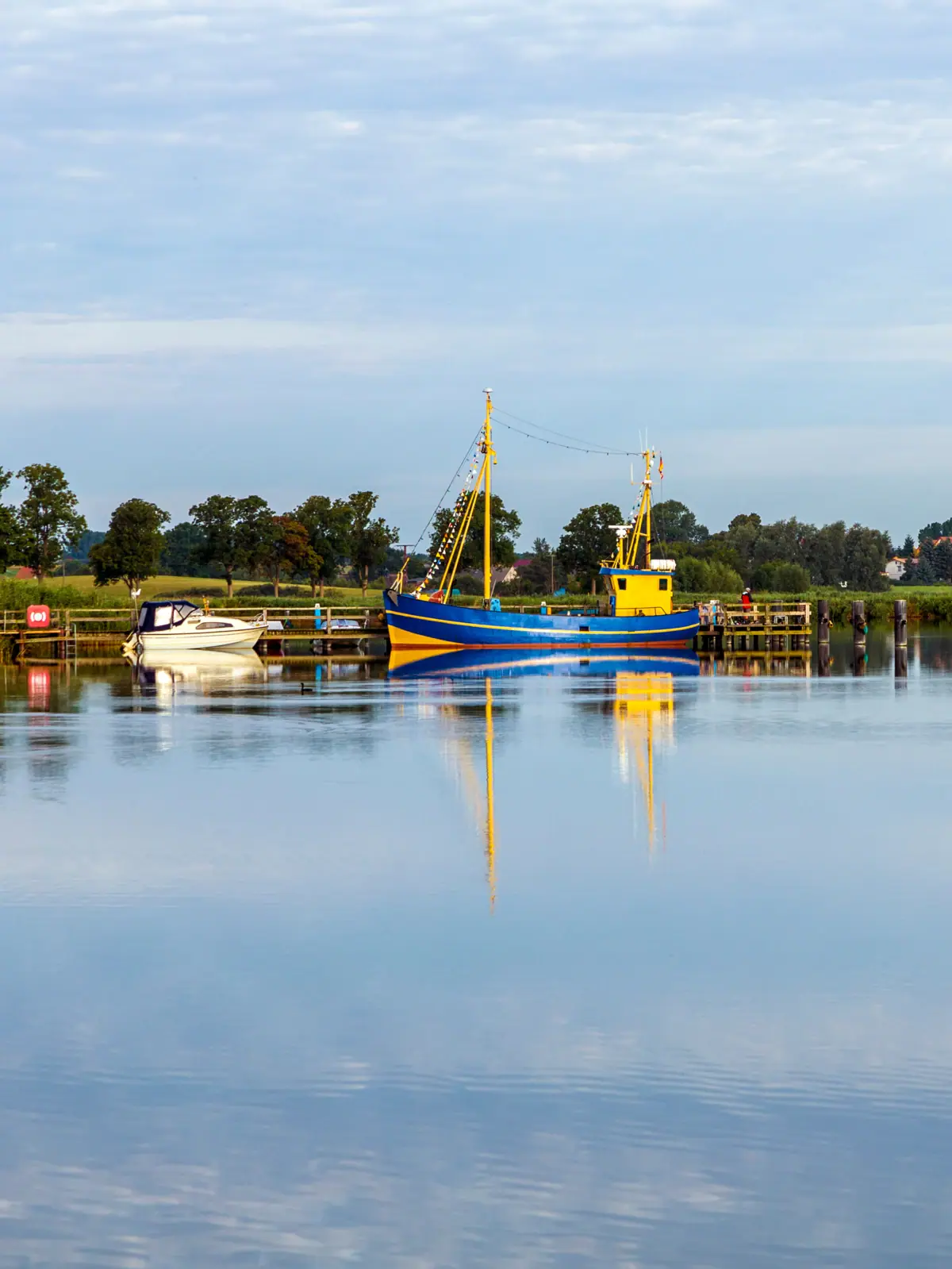 Ein Boot auf dem Achterwasser auf Usedom unter einem bewölkten Himmel.
