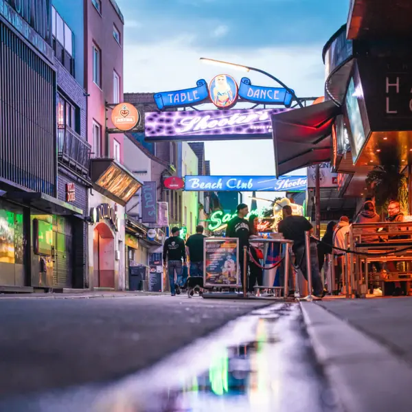 Eine Gruppe von Menschen auf der Reeperbahn bei Nacht.
