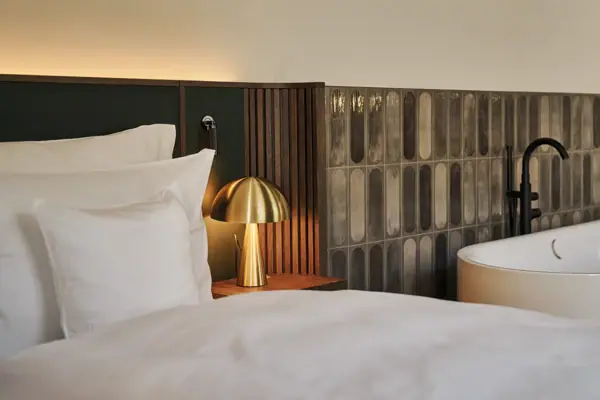 Bett neben Badewanne in einer Suite