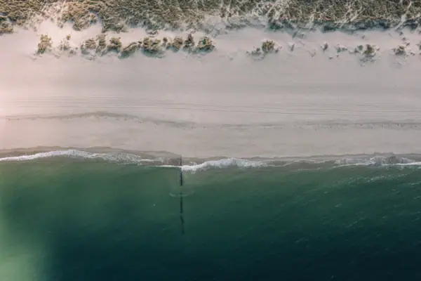 Strand mit Sand und Wasser im Freien.