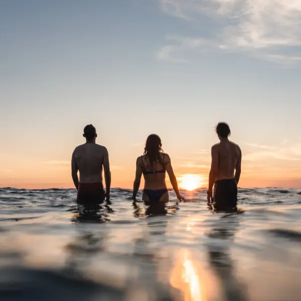Eine Gruppe von Menschen steht im Wasser in St. Peter-Ording.